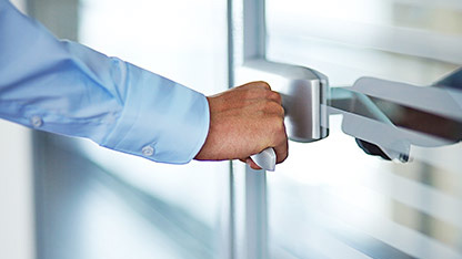 Man holding a door handle while opening the door